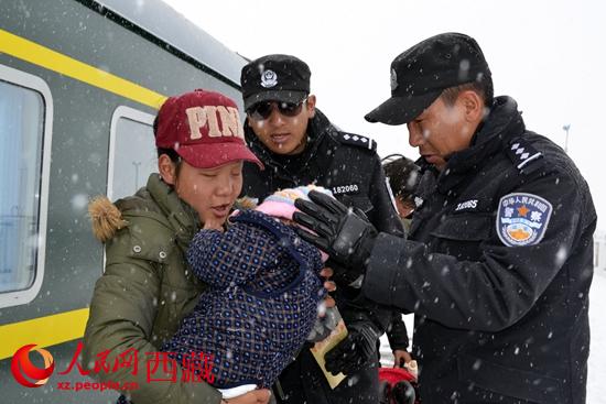 policemen protect a Tibetan woman and her little baby
