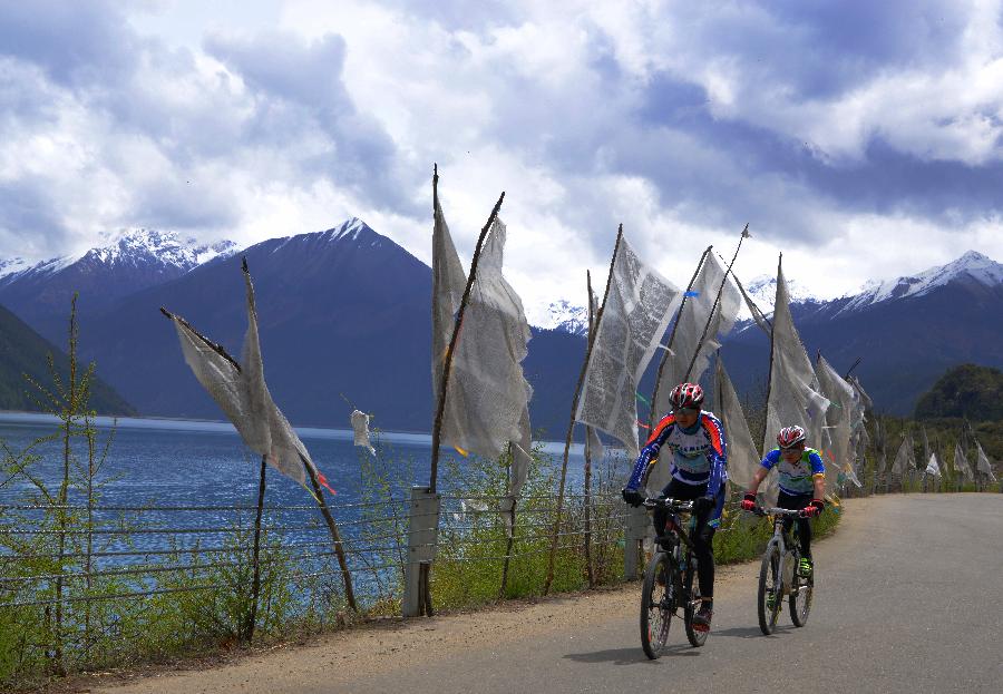 Cyclists ride beside the Basum Co Lake