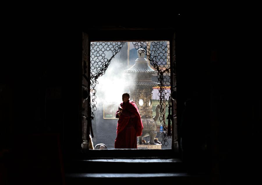 a monk walking through the main gate of Sakya Monastery.