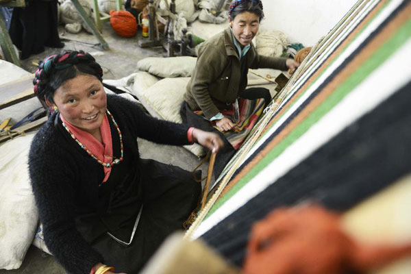 the Tibetan women weaving carpet in a traditional Tibetan carpet factory