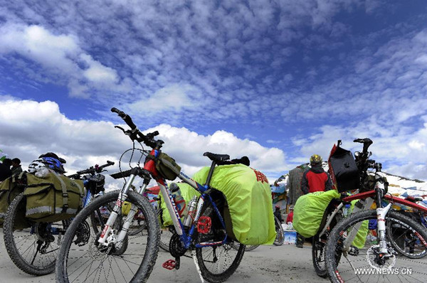 Several cyclists have a rest along the Sichuan-Tibet Highway