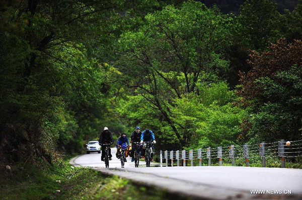 Four cyclists ride along the Sichuan-Tibet Highway