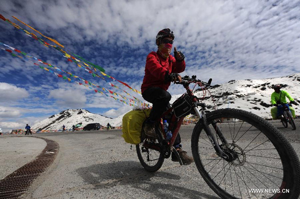 A cyclist rides along the Sichuan-Tibet Highway on the Segrila Mountain