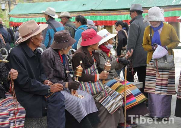  Tibetan believers take a rest along the ritual walk path in Lhasa.