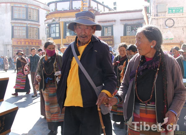 a senior Tibetan couple believing Buddhism take ritual walk around the Jokhang Temple in Lhasa during Sagadawa. 