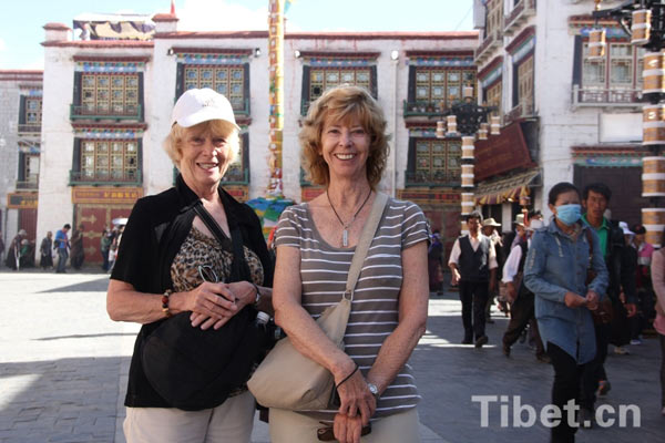 two foreign tourists on the Barkhor Street in front of the Jokhang Temple in Lhasa. 