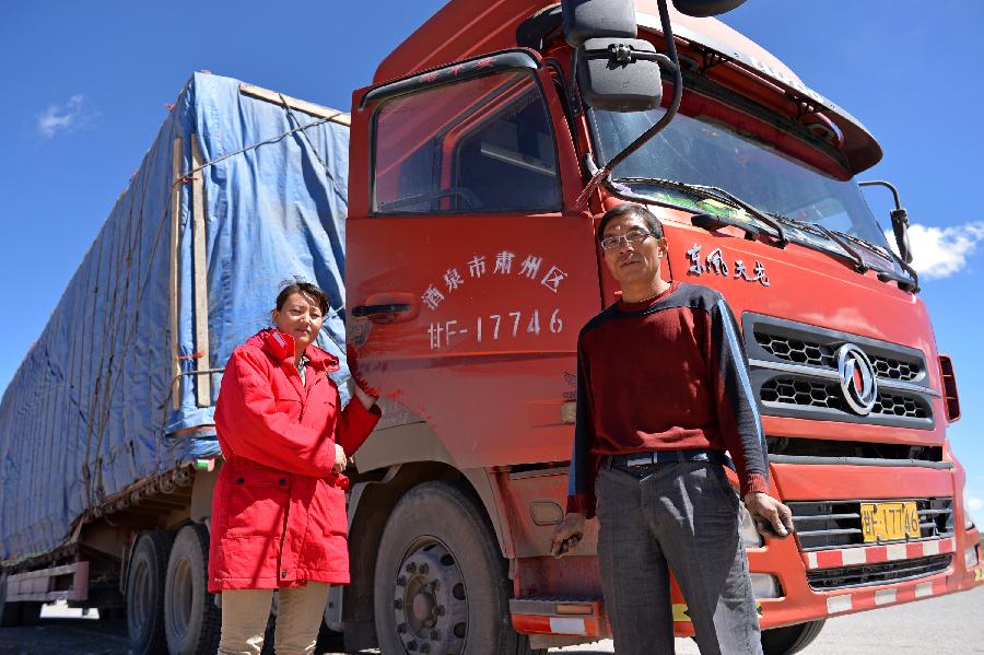 Photo taken on Sept. 19, 2014 shows Mr. Zhao (R) and his wife in front of a truck on the Hol Xil part of the Qinghai-Tibet highway, northwest China's Qinghai Province. Mr. Zhao is a truck driver working on the Qinghai-Tibet transportation line. The year of 2014 marks the 60th anniversary of the opening of the Qinghai-Tibet highway. The highway, linking Xining, capital city of Qinghai province, and Lhasa, capital of the Tibet Autonomous Region, is a lifeline for Qinghai-Tibet Plateau. It boosts economic growth of regions along the road and makes lots of people's dreams come true.