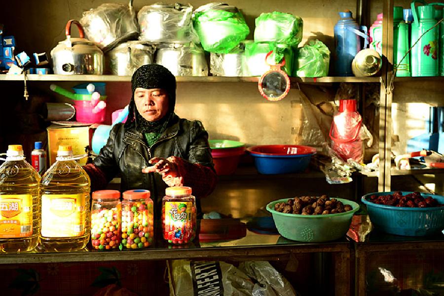 Photo taken on Sept. 20, 2014 shows Mrs. Ma of Hui ethnic group working in her own grocery shop in Yanshiping Township on the Qinghai-Tibet highway, southwest China's Qinghai Province. The year of 2014 marks the 60th anniversary of the opening of the Qinghai-Tibet highway. The highway, linking Xining, capital city of Qinghai province, and Lhasa, capital of the Tibet Autonomous Region, is a lifeline for Qinghai-Tibet Plateau. It boosts economic growth of regions along the road and makes lots of people's dreams come true.
