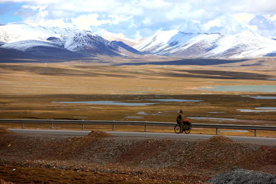 Photo taken on Sept. 20, 2014 shows Zhou Xiansheng riding bicycle on the Qinghai-Tibet highway, southwest China's Tibet Autonomous Region. Zhou, 27, gave up his job this summer to realize his dream of riding to Tibet from Chengdu, capital of southwest China's Sichuan Province. 