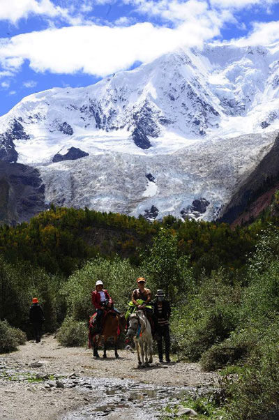 A tourist rides a horse at the Midui Glacier of Nyingchi Prefecture, Tibet