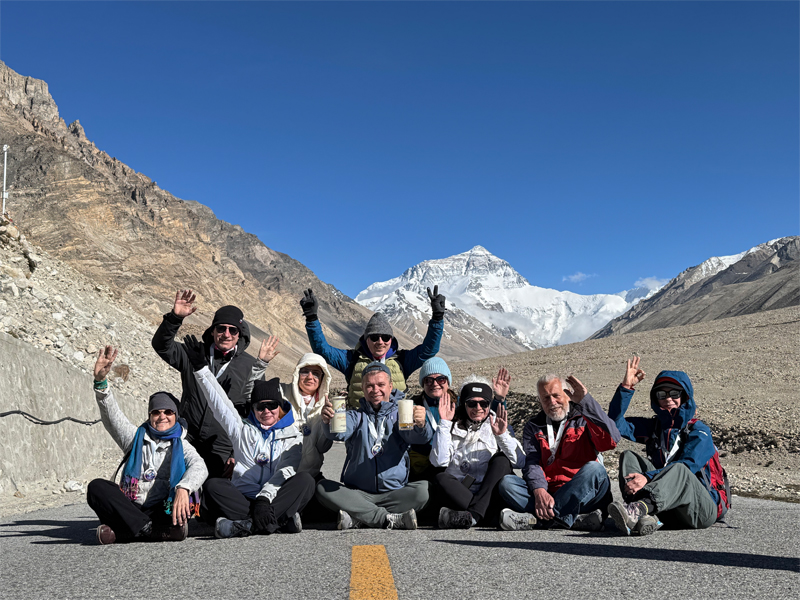 Travelers Celebrating at Everest Base Camp, Tibet Group of travelers posing in front of Mount Everest at Everest Base Camp in Tibet