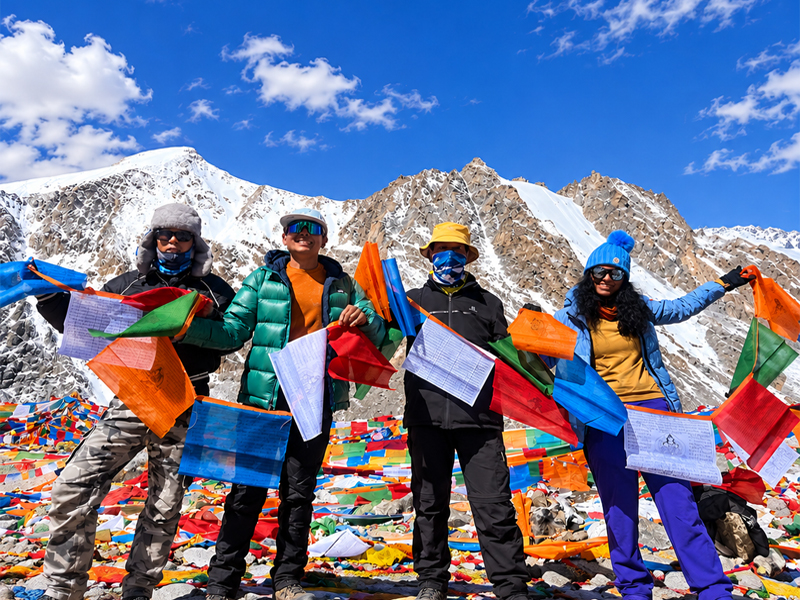 Travelers Hanging Prayer Flags at Mount Kailash Travelers hanging Tibetan prayer flags at Mount Kailash
