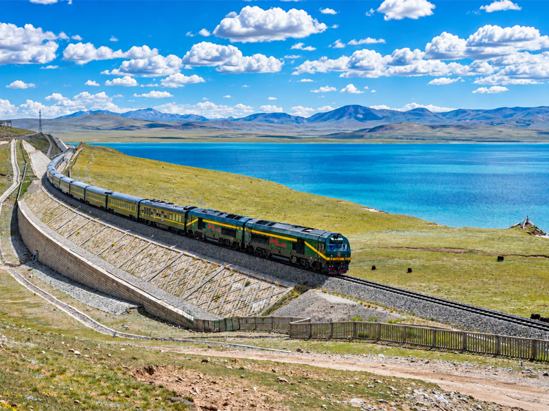 Tibet train traveling along Cuona Lake on the Qinghai-Tibet Railway Tibet train passing beside the blue waters of Cuona Lake