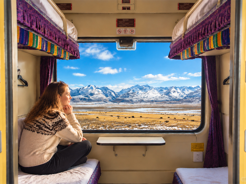 Beautiful Tibetan Plateau scenery from the Tibet train Traveler enjoying snow-capped mountains from a Tibet train window