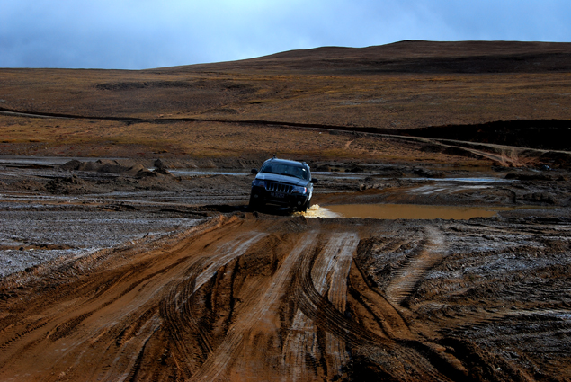 An SUV runs drives on a muddy road in Ngari Prefecture.